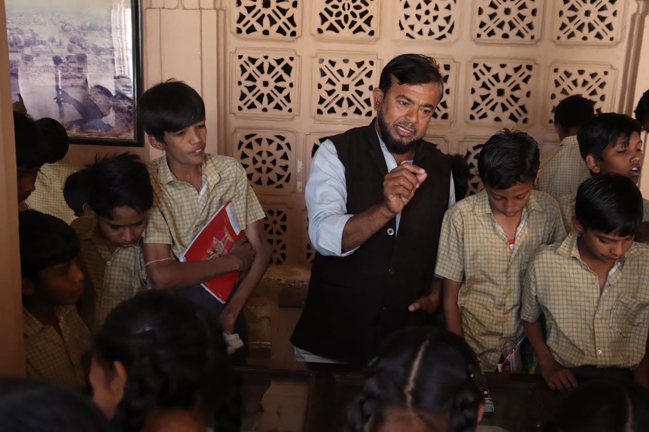 Teacher guiding attentive students during an interactive indoor lesson, fostering education.